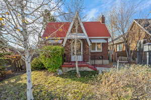 English style home featuring a chimney and brick siding