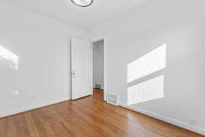 Unfurnished room with ornamental molding and light wood-style flooring