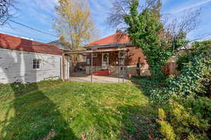 Back of property with a patio, brick siding, and a chimney
