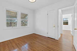 Spare room with ornamental molding and wood finished floors