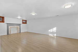 Unfurnished living room with light wood-type flooring and a fireplace