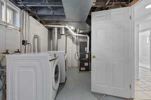 Laundry room featuring independent washer and dryer and heating unit