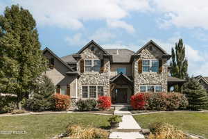 Craftsman house featuring a front lawn and stone siding