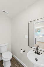 Half bath with 100% water-proof vinyl flooring, pedestal sink and large modern mirror
