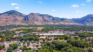 Aerial view of residential area featuring mountains and a tree filled landscape