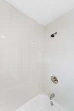 Fully renovated bathroom featuring tub/shower with tub to ceiling ceramic tile, pedestal sink and large modern mirror. Lots of space for linen storage