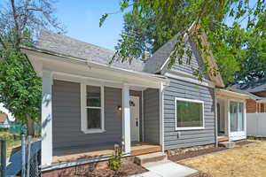 View of front of home featuring a shingled roof and covered porch