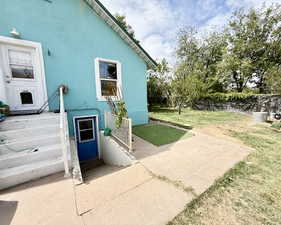 View of property exterior with stucco siding and a lawn
