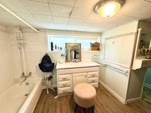 Full bath featuring vanity, wood finished floors, and shower / washtub combination