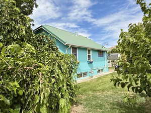 Back of property featuring a metal roof and a yard