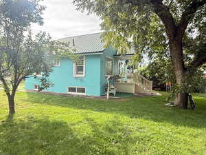 View of property exterior with a yard, a metal roof, stucco siding, and stairway
