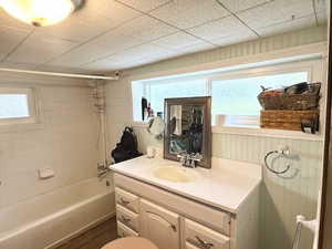 Bathroom featuring vanity, shower / washtub combination, and wood finished floors