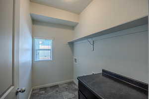 Laundry room with washer hookup, a textured ceiling, cabinet space, and stone finish flooring