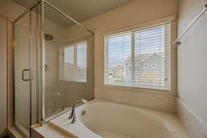 Full bath with a bath and a stall shower
