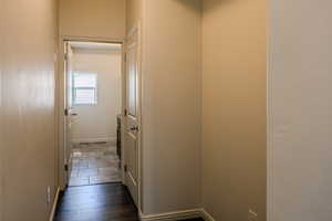Corridor with baseboards and dark wood-type flooring