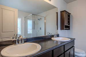 Full bath with a shower stall and double vanity