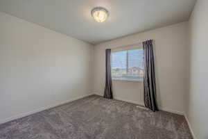 Carpeted spare room with baseboards and a textured ceiling