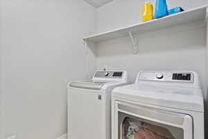 Laundry area featuring separate washer and dryer and baseboards
