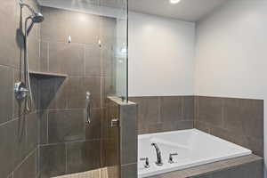 Bathroom featuring a shower stall, a bath, and recessed lighting