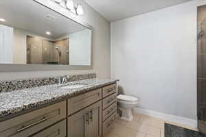 Bathroom featuring a stall shower, vanity, and recessed lighting