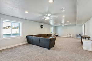 Living area featuring recessed lighting, carpet flooring, ceiling fan, and a textured ceiling
