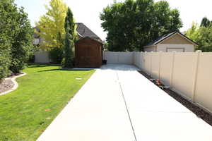Fenced backyard with a shed and a patio