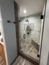Full bath featuring a shower stall, vanity, and wood finished floors