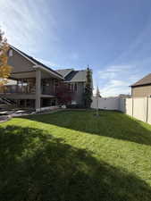View of yard featuring a balcony and a patio