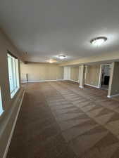 Spare room with dark carpet and baseboards