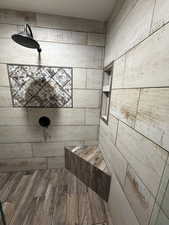 Full bathroom featuring tiled shower and wood finished floors