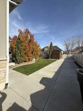 View of home's exterior with a fenced backyard and a storage shed