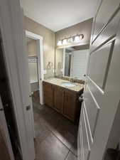 Full bathroom with vanity and a textured ceiling