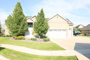 Craftsman-style house featuring board and batten siding, driveway, a garage, and a front yard