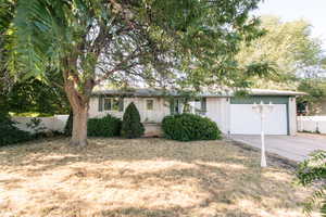 Ranch-style house featuring a garage, driveway, and brick siding