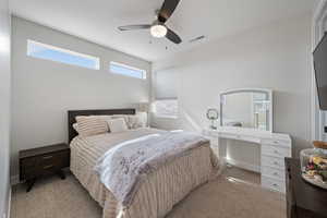 Bedroom with light carpet and a ceiling fan