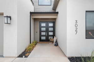 Doorway to property with french doors, stucco siding, and a garage