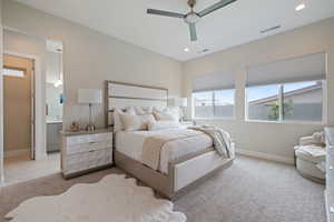 Bedroom with light colored carpet, recessed lighting, ceiling fan, and connected bathroom