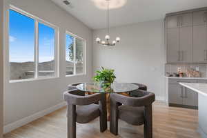 Dining space with light wood finished floors and a chandelier