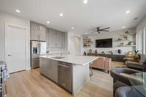 Kitchen featuring gray cabinets, open floor plan, high end appliances, ceiling fan, and recessed lighting