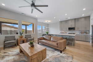 Living area with light wood-style floors, recessed lighting, and a ceiling fan