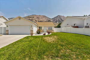 Single story home featuring brick siding, a garage, concrete driveway, and a mountain view