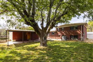 Rear view of property featuring brick siding and a patio