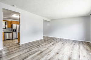 Unfurnished living room with a textured ceiling and light wood-style flooring