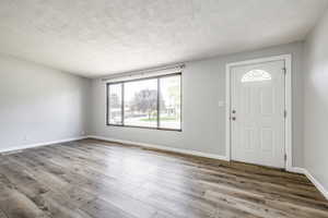Entrance foyer featuring a textured ceiling and wood finished floors