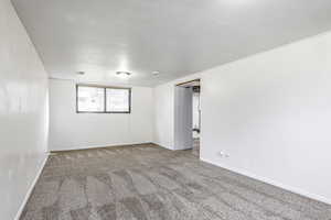 Spare room featuring carpet and baseboards