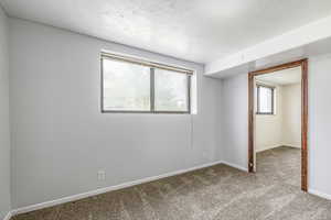 Unfurnished bedroom featuring carpet floors and a textured ceiling