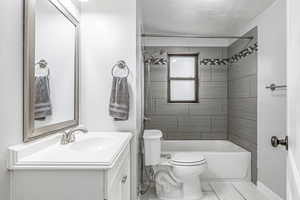 Bathroom with vanity, shower / tub combination, a textured ceiling, and tile patterned flooring
