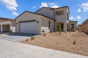View of home's exterior with a garage, concrete driveway, a tile roof, and stucco siding
