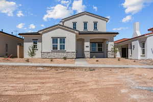 Mediterranean / spanish-style home with stone siding, stucco siding, and a tile roof