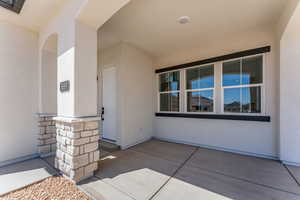 Property entrance with stone siding and stucco siding